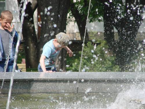хлопчик біля фонтану